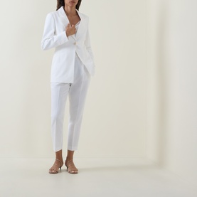 Model wearing Ted Baker Musubt White Cropped Straight Leg Trousers, styled with a matching white blazer and nude heeled mules.