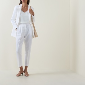 Model wearing Ted Baker Musubt White Cropped Straight Leg Trousers, styled with a white blazer and top, carrying a beige bag.