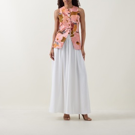 Model wearing Ted Baker Narlla Floral Print Waistcoat in coral with white wide-leg trousers and nude heels.
