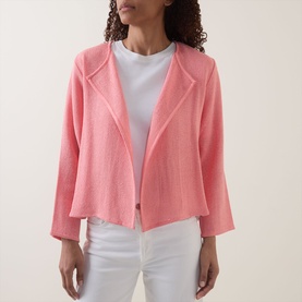 Model wearing pink open-front textured blazer jacket with notch lapels, styled with white T-shirt and white trousers