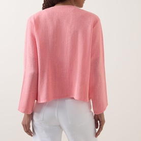 Model wearing pink long-sleeve cropped boxy top, rear view, styled with white trousers