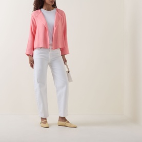 Model wearing pink cropped blazer, styled with white T-shirt, white straight-leg jeans, and yellow flat shoes, carrying small white bag