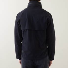 Model wearing Paul Smith blue casual jacket, back view, showing yoke panel detail and high collar with navy trousers.
