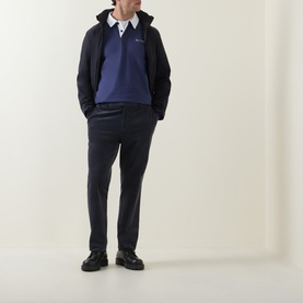 Model wearing Paul Smith blue casual jacket with navy rugby polo shirt and dark tailored trousers, styled with black leather shoes.