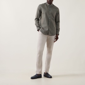 Model wearing Paul Smith blue cotton-silk casual shirt with grandad collar, styled with stone slim-fit trousers and navy loafers