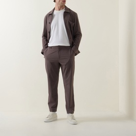 Model wearing Paul Smith grey casual trousers with matching overshirt, white T-shirt and white trainers.