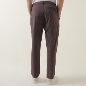 Model wearing Paul Smith grey casual trousers, rear view, slim fit with back pockets, styled with white trainers.