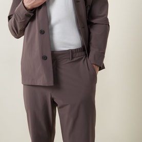 Model wearing Paul Smith grey casual trousers in elastane blend, styled with a matching grey overshirt and white T-shirt.