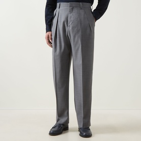 Model wearing Paul Smith Double Pleat Wool Trousers in grey, featuring double-pleated front and belt loops, styled with dark loafers.