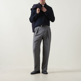 Model wearing Paul Smith Double Pleat Wool Trousers in grey, styled with a navy knit and blazer, black loafers.