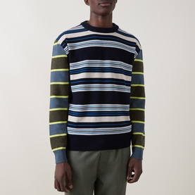 Model wearing Paul Smith blue multicolour stripe lambswool crew neck jumper, styled with khaki trousers.