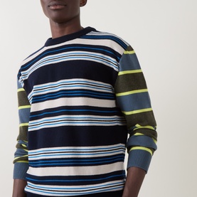 Model wearing Paul Smith blue multistripe lambswool cotton crew neck jumper with neon yellow, white and navy horizontal stripes.