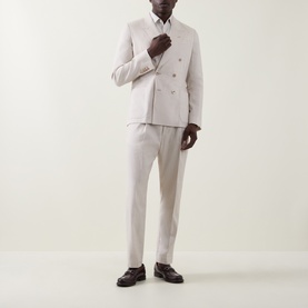 Model wearing Paul Smith white linen-wool formal trousers, styled with matching double-breasted blazer and dark brown loafers.