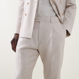 Model wearing Paul Smith white linen-wool formal trousers with a matching double-breasted blazer and grey shirt.