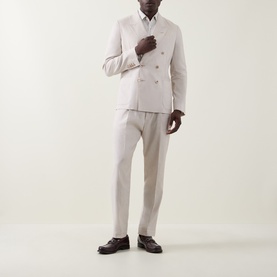 Model wearing Paul Smith white linen-wool double-breasted jacket with matching trousers and brown leather loafers.