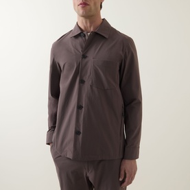 Model wearing Paul Smith grey lightweight jacket with spread collar, button front, and chest pocket, styled with matching grey trousers.