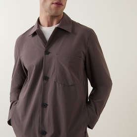 Model wearing Paul Smith grey button-front jacket with chest patch pocket, styled over white crew-neck tee.