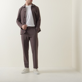 Model wearing Paul Smith grey jacket with white T-shirt and matching grey trousers, styled with white trainers.