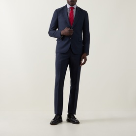 Model wearing Paul Smith navy wool suit with red tie and black leather shoes.