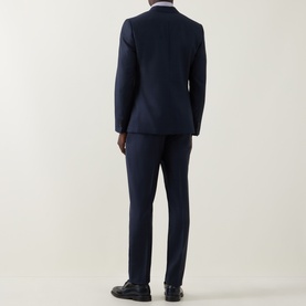 Model wearing Paul Smith navy wool suit, rear view, styled with a light shirt and black oxford shoes.