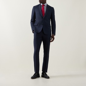 Model wearing Paul Smith navy wool suit, styled with white shirt, red tie and black leather oxford shoes