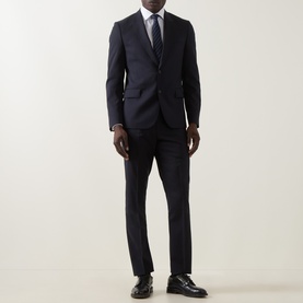 Model wearing Paul Smith Soho Pinstripe Single-Breasted Two-Piece Suit in navy wool, styled with a light blue tie and black Oxford shoes.