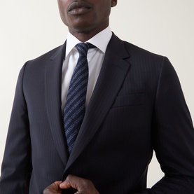 Model wearing Paul Smith Soho Pinstripe Single-Breasted Two-Piece Suit in navy wool, styled with white shirt and navy striped tie.