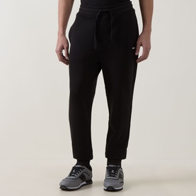 Model wearing Hugo black cotton sweatpants with drawstring waist and tapered leg, styled with grey trainers