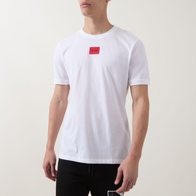 Model wearing Hugo white cotton T-shirt with signature red logo label at chest