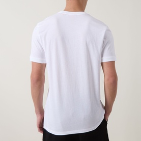 Model wearing Hugo white cotton T-shirt, rear view, short sleeves, curved hem, styled with black trousers.