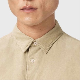 Model wearing All Saints cord brown corduroy shirt, close-up detail of button-down collar and fine ribbed texture