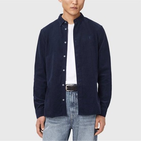 Model wearing All Saints sapphire blue corduroy shirt with button-down collar, styled with light wash jeans and white belt.