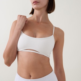 Model wearing Tala DayFlex Strappy Back Sports Bra in Ivory, featuring scoop neckline, keyhole front detail and thin adjustable straps.