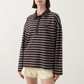 Model wearing Tala Striped Logo Rugby Top in Mocha Brown with polo collar, long sleeves and front button fastenings, styled with pale yellow shorts.
