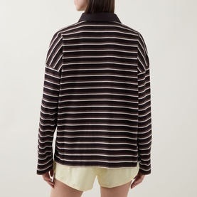 Model wearing Tala Striped Logo Rugby Top in Mocha Brown, back view, polo collar, long sleeves, paired with yellow shorts.