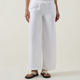 Model wearing Tala Soft Wide Leg Ivory Trousers with drawstring waist and wide leg fit, styled with black flat sandals