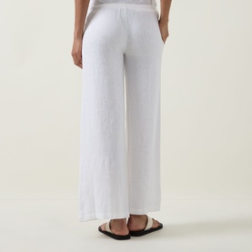 Model wearing Tala Soft Wide Leg Trousers in ivory, wide-leg linen-viscose blend with elasticated waist, styled with black flat sandals.