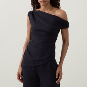 Model wearing Tala Shadow Black one-shoulder linen-viscose top with ruched side, styled with matching wide-leg trousers