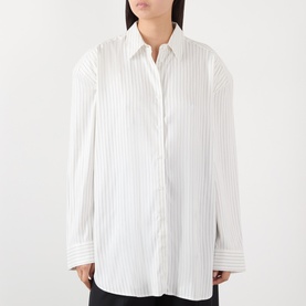 Model wearing The Frankie Shop shirt in white and black stripe, relaxed oversized fit, long sleeves, classic collar, button-front