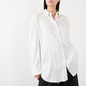 Model wearing The Frankie Shop shirt in white and black stripe, relaxed oversized fit with classic collar and long sleeves