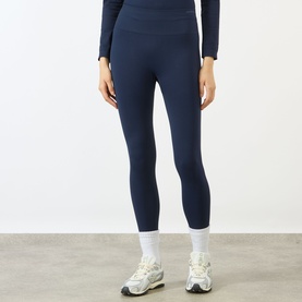 Model wearing Adanola navy blue seamless leggings, styled with a matching long-sleeve top and white trainers