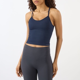 Model wearing Adanola navy blue tank top with thin cross-back straps, styled with grey high-waist leggings