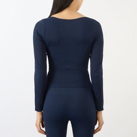 Model wearing Adanola navy blue long-sleeve fitted top, back view, styled with matching navy leggings.