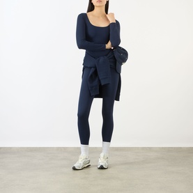 Model wearing Adanola navy blue long-sleeve fitted top with matching leggings, navy shirt tied at waist, white socks and trainers.