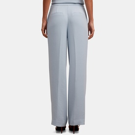 Model wearing Forever New Ice Blue wide-leg trousers, rear view, with centre front crease detail and wide hem.