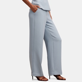 Model wearing Forever New Ice Blue wide-leg trousers with front seam detail, styled with matching top and black heeled sandals.