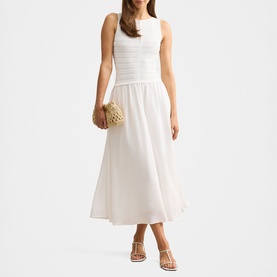 Model wearing Forever New porcelain midi dress with ruched bodice and full skirt, styled with nude strappy heels and woven clutch bag