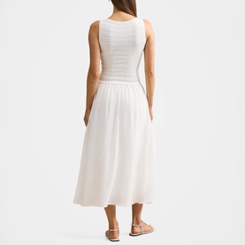 Model wearing Forever New porcelain midi dress with ruched bodice and flowy skirt, styled with tan flat sandals, shot from behind.
