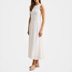 Model wearing Forever New porcelain sleeveless midi dress with ruched bodice and flowy skirt, styled with white strappy heeled sandals.