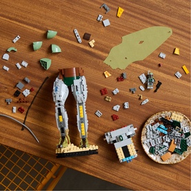 Lego Star Wars multi-coloured building set partially assembled on wooden surface, with scattered bricks and instruction booklet visible